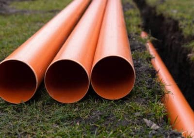 septic pipe plumbing close up with one length sitting in a excavated ditch