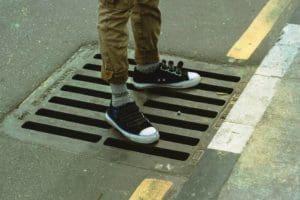 a person is standing on the sewage tank access