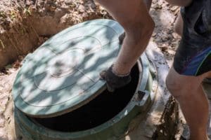 a person is opening the lid of the septic tank