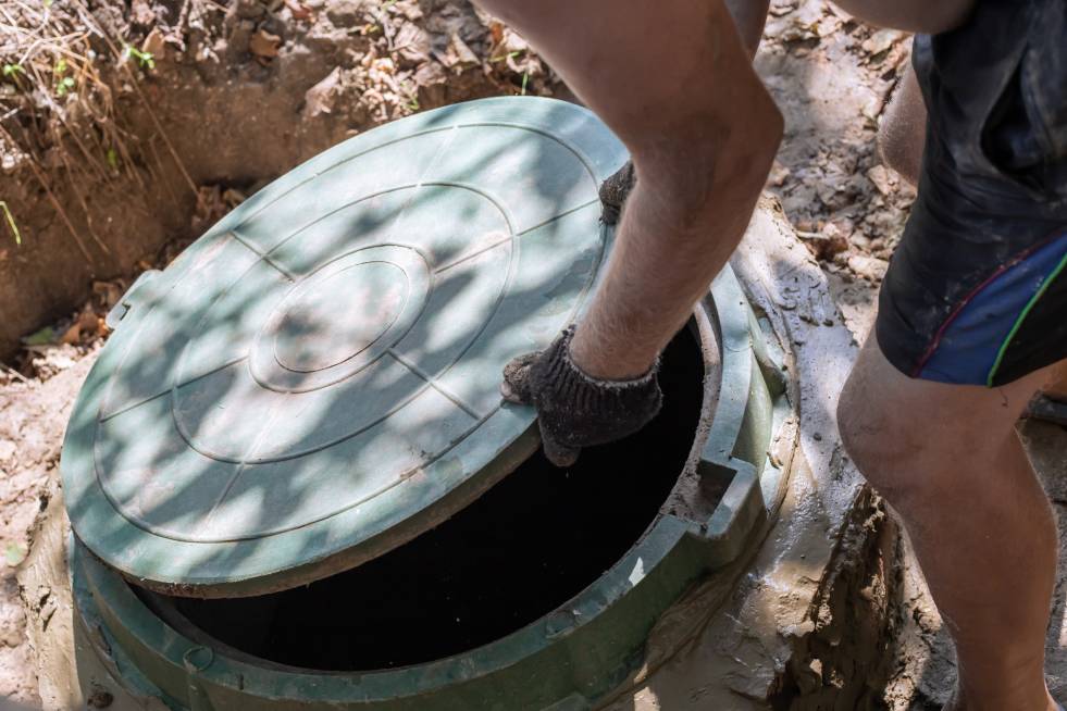 a person is opening the lid of the Septic systems