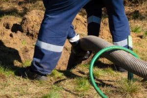 a technician pumping a septic tank
